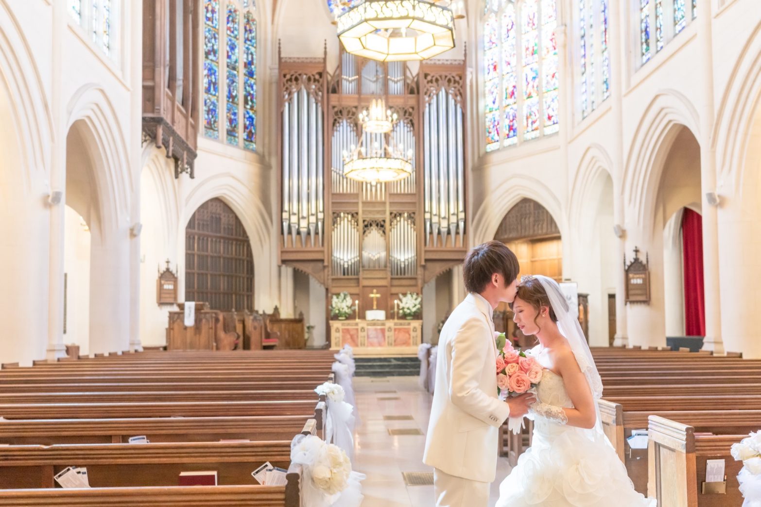 祭壇をバックにヴァージンロードで誓いのキス
